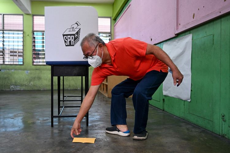 Seorang pria menjatuhkan surat suaranya sebelum memberikan suaranya di tempat pemungutan suara selama pemilihan negara bagian di Selayang, negara bagian Selangor Malaysia pada 12 Agustus 2023. 