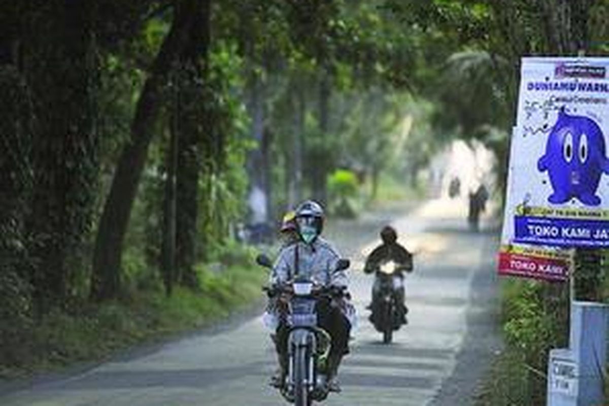 Pengendara motor mengenakan masker untuk menghindari hujan abu saat melintas di kawasan Cemorokandang, Kota Malang, Jawa Timur, Sabtu (1/8). Badai besar di puncak Gunung Semeru yang diembuskan angin ke sisi barat gunung tertinggi di Pulau Jawa tersebut membuat kawasan Malang bagian timur dan tenggara terkena dampak hujan abu. Saat ini Gunung Semeru berstatus waspada.