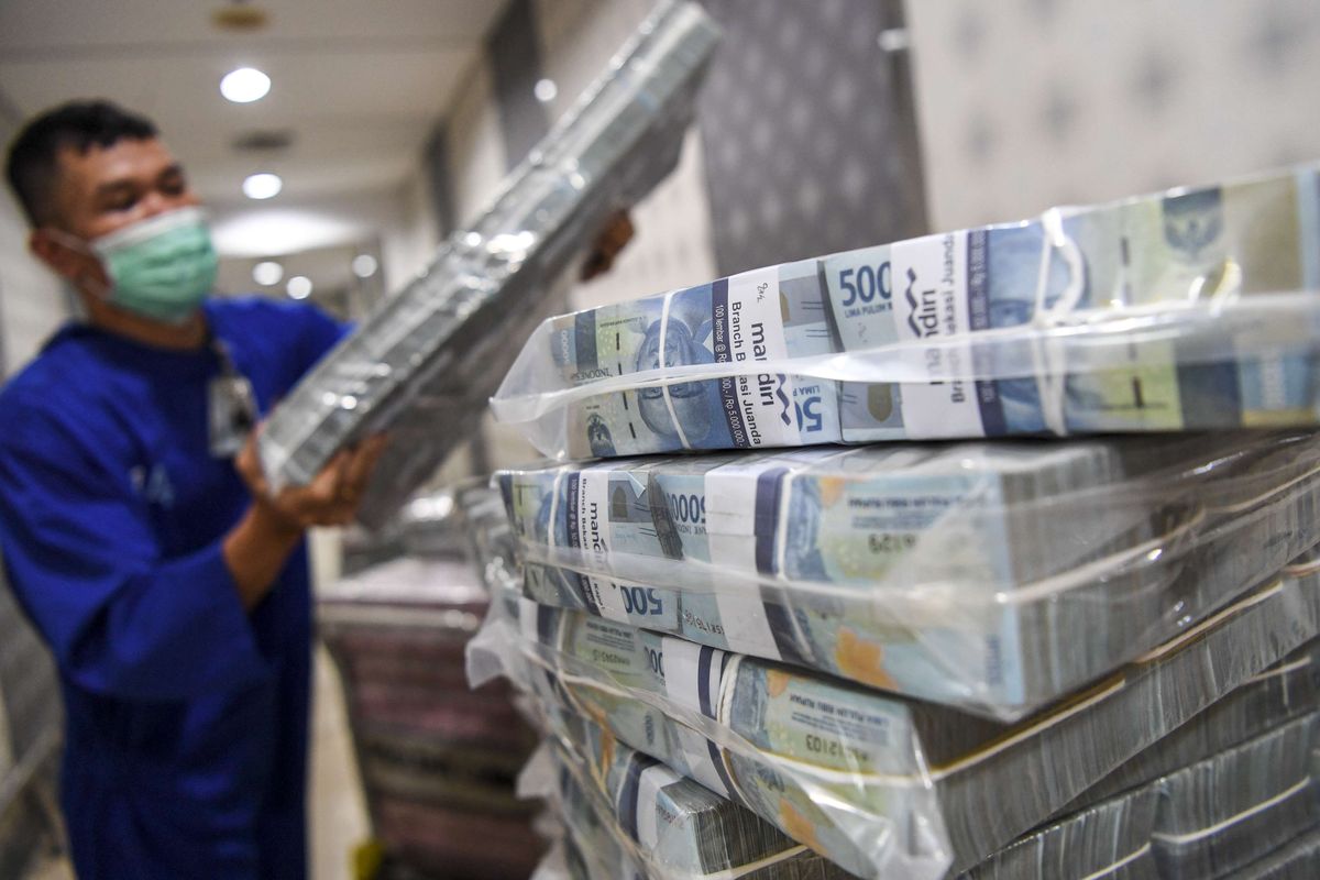 Pegawai menata uang tunai pecahan Rp 50.000 yang akan dikirimkan ke kantor cabang di Sentra Kas Bank Mandiri, Jakarta, Rabu (6/4/2022).