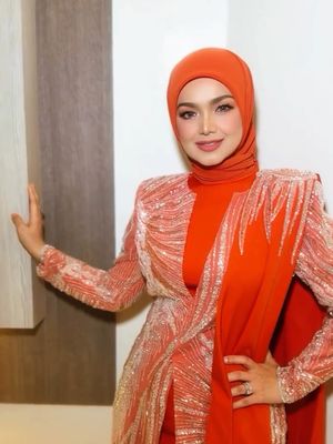 Siti Nurhaliza tampil memukau di Pestapora 2025 dengan hijab oranye terang, setelan berpayet, dan makeup soft glam yang elegan.