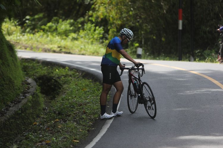 Peserta Cycling De Jabar yang berhenti sesaat untuk mengambil nafas ketika melalui jalur menanjak di Ciletuh, Sukabumi, Jawa Barat, Sabtu (27/8/2022).