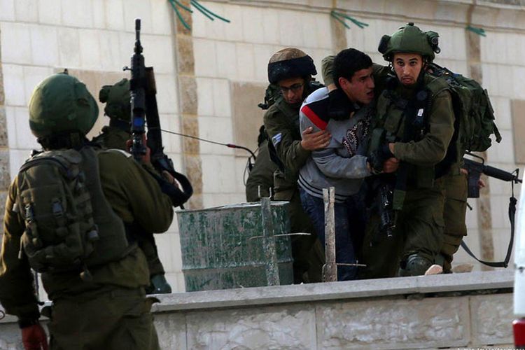 Tentara Israel menahan seorang Palestina yang melakukan aksi protes di Tepi Barat, Desember 2017 lalu.