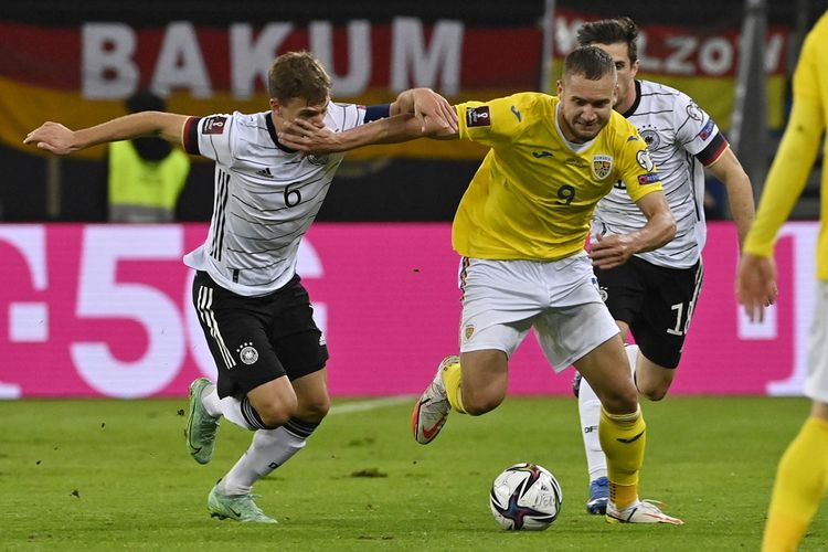 Gelandang timnas Jerman Joshua Kimmich (kiri) berduel dengan penyerang Rumania George Puscas dalam laga lanjutan Kualifikasi Piala Dunia 2022 Zona Eropa di Stadion Volkspark, Sabtu (9/10/2021) dini hari WIB.