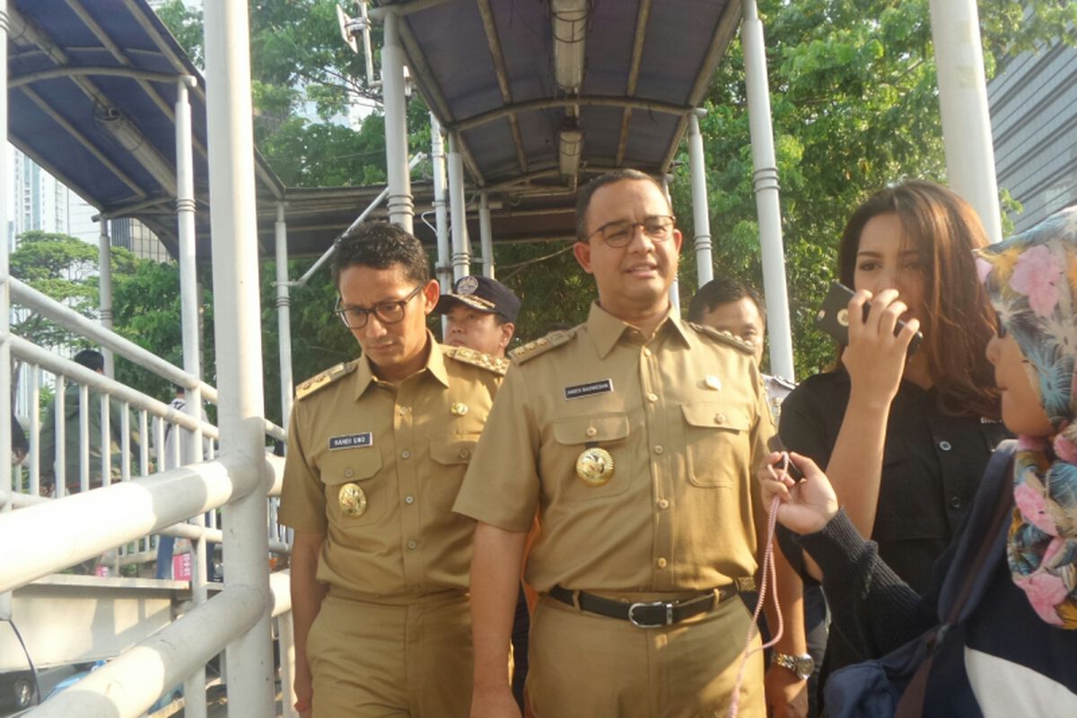 Gubernur DKI Jakarta Anies Baswedan dan Wakil Gubernur Sandiaga Uno di Halte Dukuh Atas saat akan menaiki bus transjakarta, Selasa (17/10/2017). 