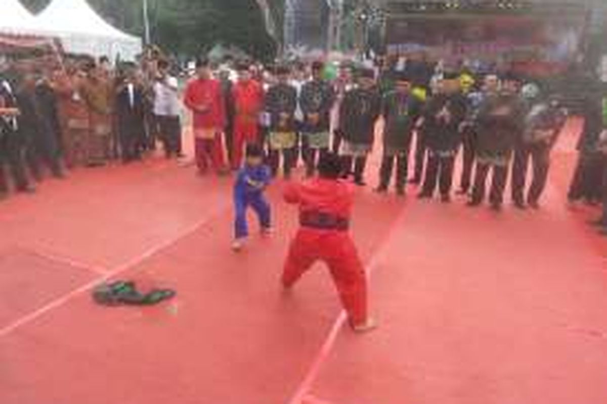 Dua orang anak yang tengah memperagakan jurus silat Betawi dalam acara Lebaran Betawi 2016 di Lapangan Betawi, Gambir, Jakarta Pusat, Minggu (14/8/2016).