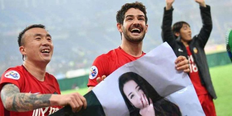 Pemain Tianjin Quanjian, Alexandre Pato (kanan) bersama rekan setimnya memegang poster yang berisi foto dirinya bersama artis China, Dilraba Dilmurat, yang diberikan fans, setelah menang 4-1 atas Jeonbuk Motors di Liga Champions Asia, Rabu (14/3/2018)