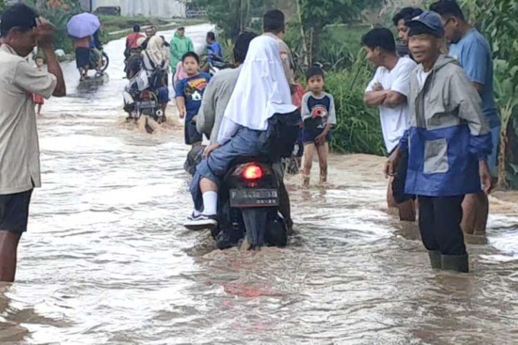 Sejumlah kendaraan melintas di ruas jalan yang terendam banjir di wilayah Kecamatan Cibeber, Cianjur, Jawa Barat, Selasa (6/9/2022).