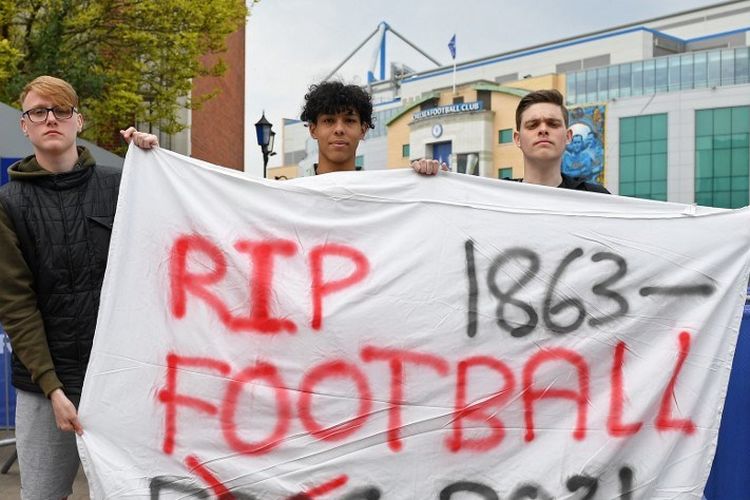 Sejumlah suporter membentangkan spanduk protes kepada gagasan European Super League jelang laga Liga Inggris 2020-2021 antara Chelsea vs Brighton di Stadion Stamford Bridge, 20 April 2021. (Photo by JUSTIN TALLIS / AFP)
