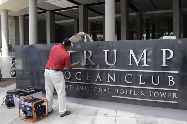 Seorang pekerja mencabut nama Trump dari sebuah kompleks hotel dan apartemen mewah di Panama City, Panama, Senin (5/3/2018).