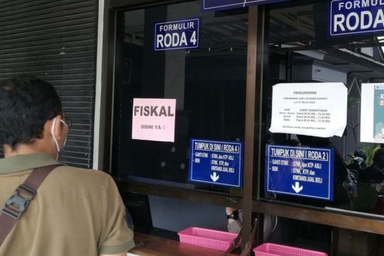 Seorang wajib pajak menunggu berkas di depan loket fiskal di kantor Samsat Kota Solo.