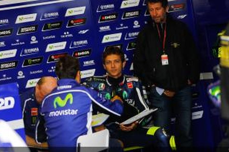 Pebalap Movistar Yamaha asal Italia, Valentino Rossi, berdiskusi dengan tim di paddock Sachsenring pada sesi kualifikasi GP Jerman, Sabtu (12/7/2014).