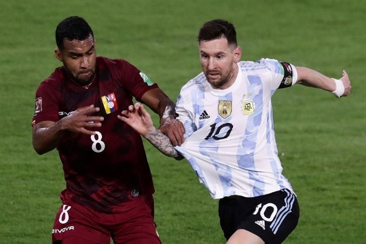 Penyerang timnas Argentina Lionel Messi berduel dengan pemain Venezuela Yangel Herrera dalam laga lanjutan Kualifikasi Piala Dunia 2022 Zona Amerika Selatan di Stadion La Bombonera, Buenos Aires, pada Sabtu (26/3/2022) pagi WIB.