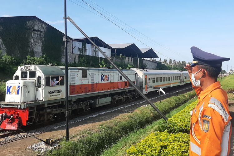 Sahabir (48) penjaga jalan lintasan (PJL) berdiri di depan pos perlintasan kereta berpintu Jalan Argopuro, Kecamatan Kalipuro, Kabupaten Banyuwangi, Jawa Timur, Sabtu (18/12/2021).