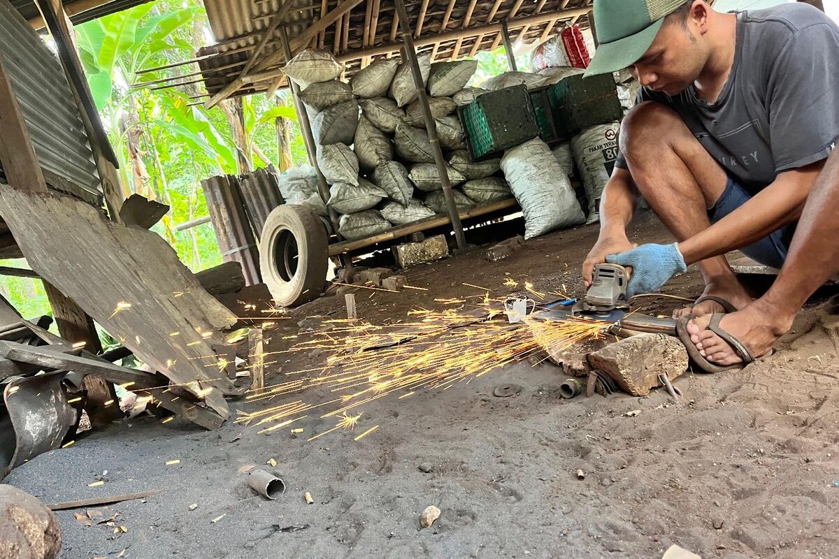 Rudianto perajin besi atau pande besi saat membuat peralatan di rumahnya Wonosari, Gunungkidul. Selasa (14/5/2024)