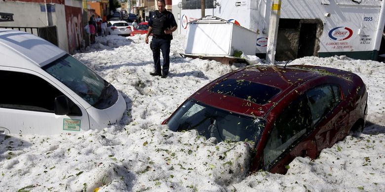 Tumpukan salju setebal lebih dari satu meter menyebabkan kendaraan tertimbun usai badai salju yang menerjang kota Guadalajara, Meksiko, Minggu (30/6/2019).