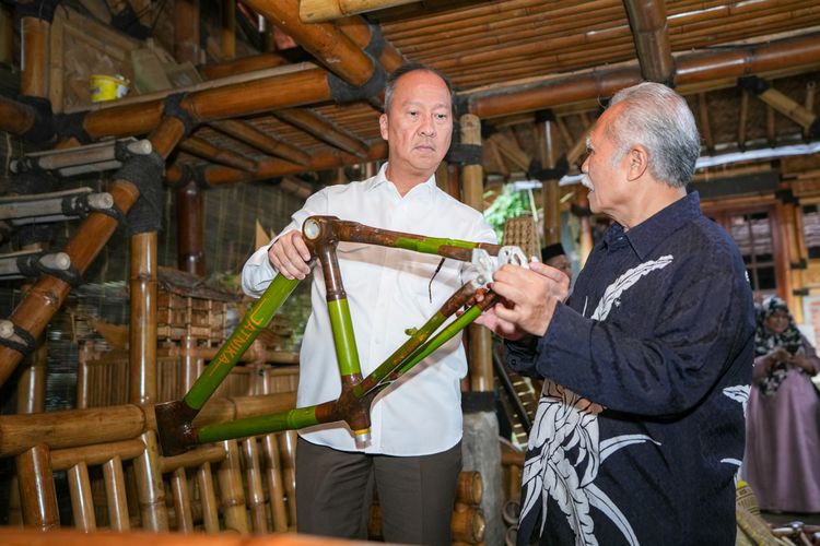 Menteri Perindustrian Agus Gumiwang Kartasasmita (kiri) mendengarkan penjelasan dari Jatnika Nanggamiharja (kanan) mengenai kerangka bodi sepeda yang terbuat dari bambu di Kabuyutan Bambu Muara Beres, Cibinong, Bogor, Jawa Barat, Senin (26/5/2025).