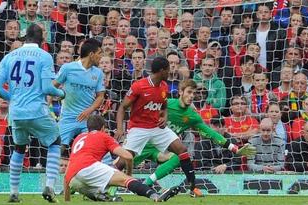 Striker Manchester City, Mario Balotelli (kiri), mencetak gol, membuka kemenangan timnya 6-1 atas Manchester United dalam partai Premier League, Minggu (23/10/2011).