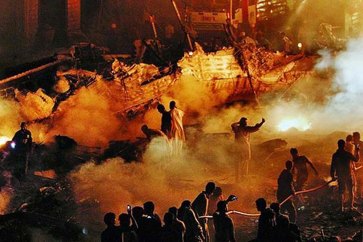 Tenaga-tenaga sukarelawan dan pasukan pemadam kebakaran berjuang memadamkan api di lokasi jatuhnya pesawat di Karachi, Pakistan, Minggu (28/11). Pesawat kargo ini jatuh ke sebuah kompleks perumahan di Karachi, kota terbesar di Pakistan, hanya beberapa saat setelah lepas landas. Delapan kru di dalamnya dinyatakan tewas.