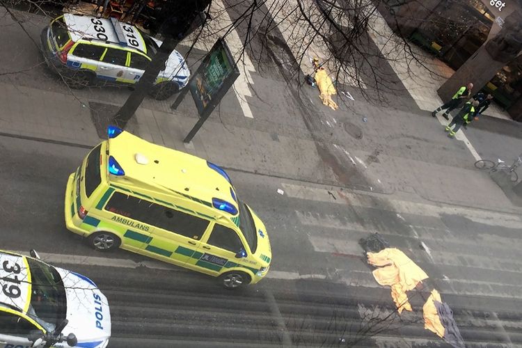 Sebuah ambulans berhenti di dekat salah seorang korban dalam teror truk di Stockholm, Jumat (7/4/2017).