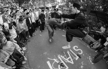 Seorang pemain Lenong Betawi dari Sanggar Kembang Kelapa, sedang membenahi pakaiannya, membelakangi mural karya komunitas  Urbanspace di Kelurahan Jagakarsa, Jakarta Selatan.