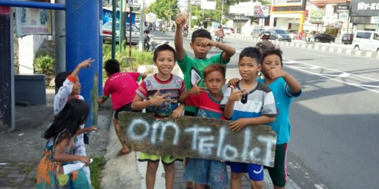 Anak-anak kecil membawa papan bertuliskan Om telolet saat didekat terminal Jombor, Sleman