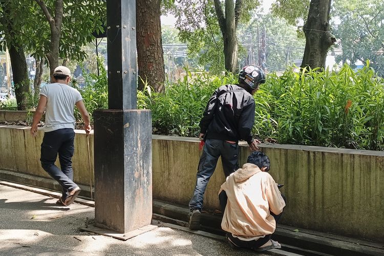 Sejumlah warga dari muda hingga tua sedang mencari koin aplikasi Jagat yang konon bernilai ratusan ribu hingga jutaan rupiah di Taman Tegalega, Kota Bandung, Jawa Barat, Jumat (10/1/2025).