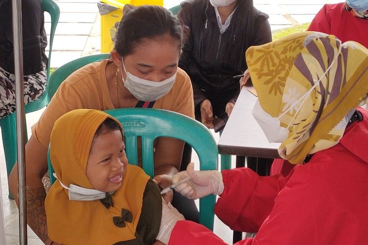 Seorang siswi TK didampingi ibunya saat disuntik vaksin dalam kegiatan vaksinasi massal untuk anak usia 6-11 tahun yang digelar Pemkot Tegal di Alun-alun Kota Tegal, Rabu (15/12/2021).