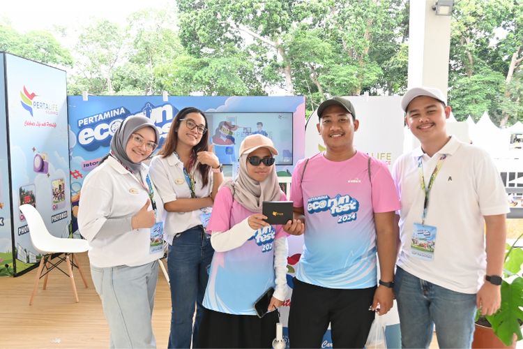 Peserta Pertamina Eco RunFest 2024 berfoto bersama tim PertaLife Insurance di stan interaktif, yang menghadirkan berbagai aktivitas seru dan merchandise menarik