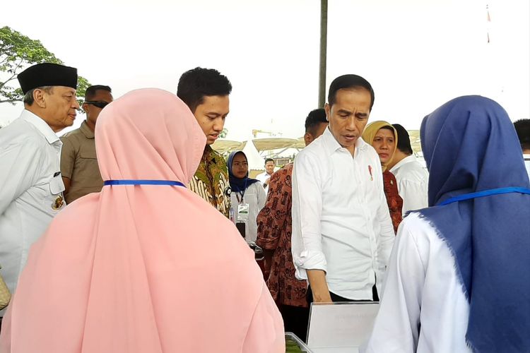 Presiden Jokowi saat meninjau produk UMKM ibu-ibu nasabah program membina ekonomi keluarga sejahtera (Mekaar) binaan Permodalan Nasional Madani (PNM) di Alun-Alun Cilegon, Banten, Jumat (6/12/2019).