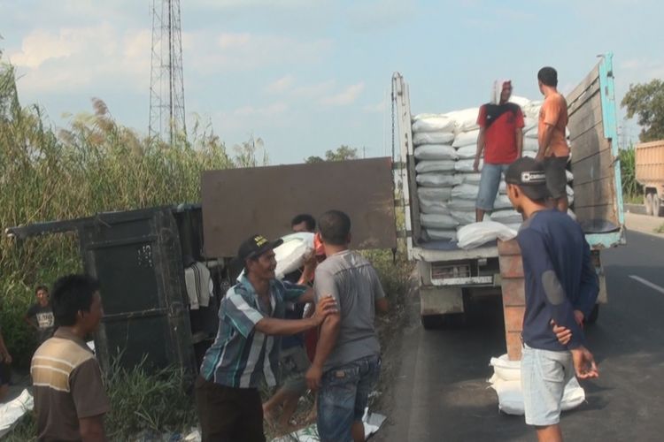 Para pekerja harus didatangkan dari gudang untuk memindahkan gula dari truk yang terbalik ke truk baru yang didatangkan