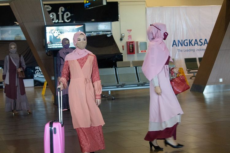 Seorang pegawai bandara tengah memeragakan busana muslim koleksi Lebaran 2021. Ini dilakukan untuk mengobati kerinduan para traveller dengan suasana bandara. 
