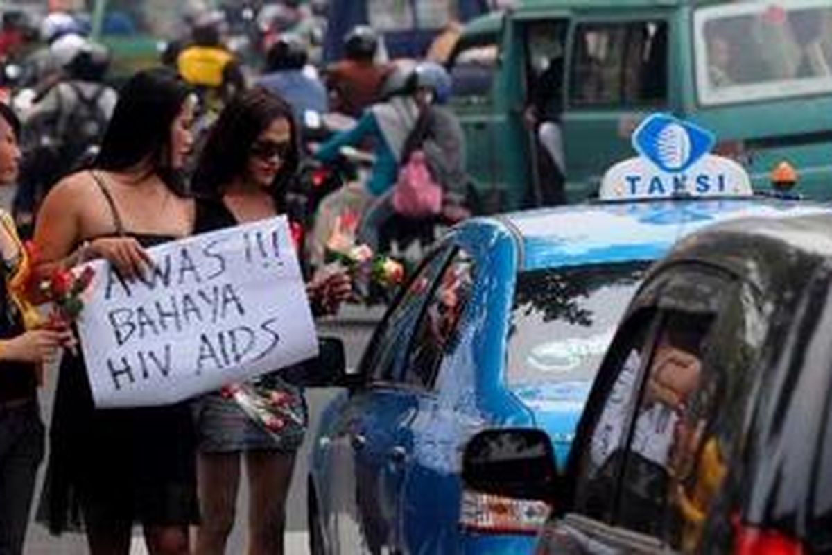 Sejumlah waria yang tergabung dalam Gerakan Waria Indonesia (GWI) menggelar aksi damai dengan membagikan bungan mawar di perempatan Jalan Raya Darmo dan Jalan Diponegoro, Surabaya, Rabu (1/12/2010). Mereka mengingatkan pengguna jalan tentang bahaya HIV/AIDS dan tidak sembarangan berhubungan seksual.