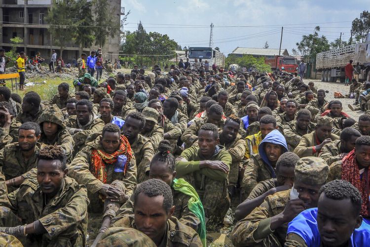 Tentara pemerintah Ethiopia yang ditangkap dan anggota milisi sekutu duduk dalam barisan setelah diarak oleh pasukan Tigray melalui jalan-jalan dengan truk terbuka, saat mereka tiba untuk dibawa ke pusat penahanan di Mekele, ibu kota wilayah Tigray di Ethiopia utara pada 22 Oktober 2021. 