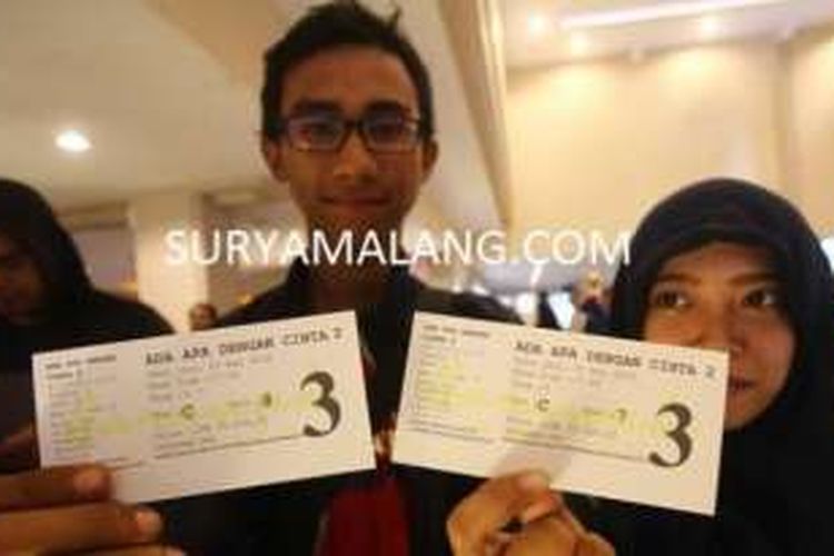 ANTRE SATU JAM - Sepasang remaja menunjukkan tiket film Ada Apa Dengan Cinta? 2 untuk pemutaran 1 April 2016 di Sarinah Cineplex, Kota Malang, Kamis (28/4/2016). 