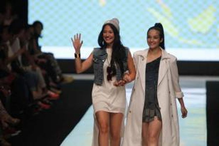 Artis Pevita Pearce (kiri) berpose dengan model yang mengenakan busana rancangannya pada Jakarta Fashion Week 2014 di Senayan City, Jakarta, Minggu (20/10/2013). Sebanyak 240 desainer dan fashion label ambil bagian dalam acara yang berlangsung hingga 25 Oktober ini.