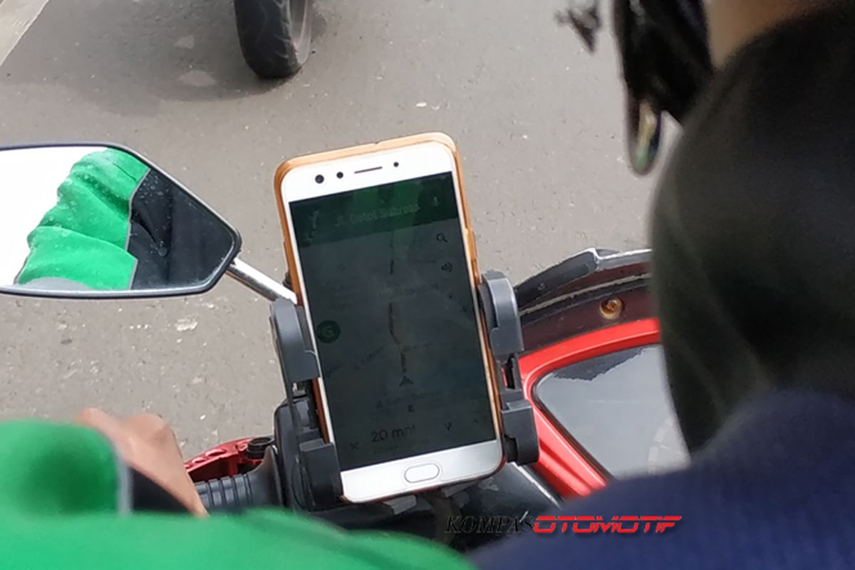 Ojek online menggunakna GPS pada ponsel saat berkendara mengantar dan menjemput penumpang.