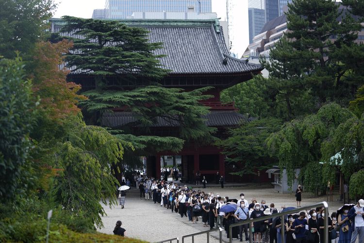 Orang-orang mengantre sebelum berdoa untuk menghormati mantan Perdana Menteri Jepang Shinzo Abe di kuil Zojoji sebelum pemakamannya di Tokyo pada Selasa, 12 Juli 2022.