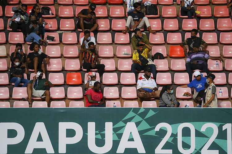 Warga menyaksikan pertandingan babak enam besar sepak bola putra PON XX Papua 2021 antara Tim Papua melawan Tim Aceh di Stadion Mandala, Kota Jayapura, Papua, Rabu (6/10/2021). Sejumlah laporan dari PON XX Papua menunjukkan sebagian penonton yang hadir di venue pertandingan ditemukan masih lalai terhadap protokol kesehatan, seperti tidak mengenakan masker dan mengabaikan pembatasan jarak.