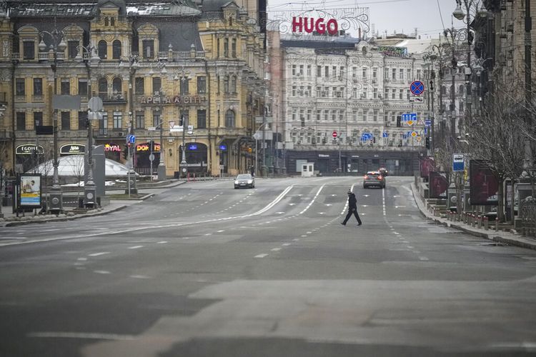 Seorang pria melintasi bulevar yang sepi selama alarm serangan udara, di Kyiv, Ukraina, Selasa, 1 Maret 2022.