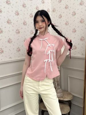 Model mengenakan cheongsam pink polos dengan cuttingan sederhana.