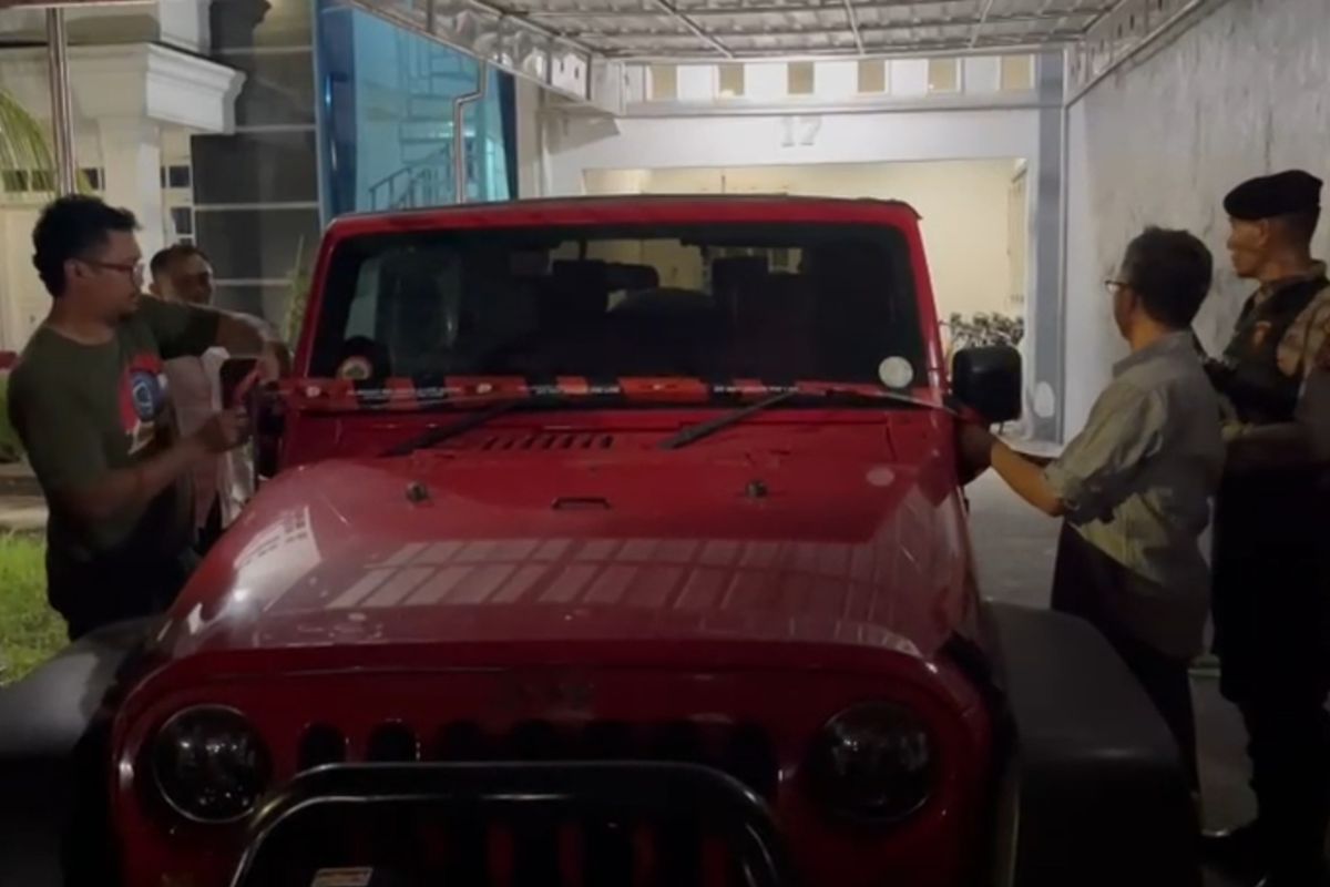 SITA--Tim KPK menyematkan tali plastik merah bertuliskam KPk sebagai tanda mobil Rubicon warnah merah milik Direktur RSUD dr Harjono Ponorogo, Yunus Mahatma disita dalam kasua jual beli jabatan di Pemkab Ponorogo, Kamis (13/11/2025) malam. 