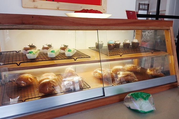 Rak berisi dessert seperti eclair dan roti bulat di Hodai AYCE, Kota Malang.