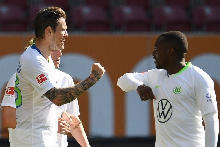 Pemain depan Wolfsburg, Daniel Ginczek (kiri) dari Jerman merayakan dengan rekan satu timnya setelah mencetak gol kedua timnya selama pertandingan sepak bola Bundesliga divisi satu Jerman FC Augsburg v VLL Wolfsburg pada 16 Mei 2020 di Augsburg, Jerman selatan, saat musim dilanjutkan setelah dua bulan tidak ada karena pandemi coronavirus COVID-19 novel.