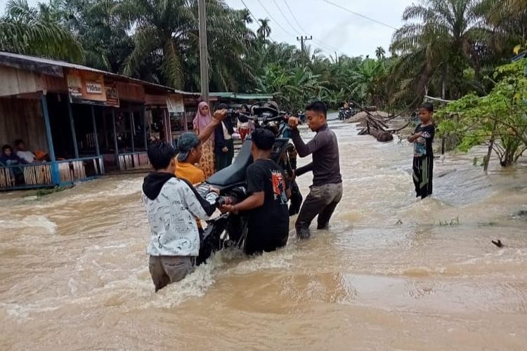 Warga mengangkat sepeda motor di lokasi banjir Desa Lae Mate, Kecamatan Rundeng, Kota Sibulussalam, Aceh, Rabu (2/11/2022)