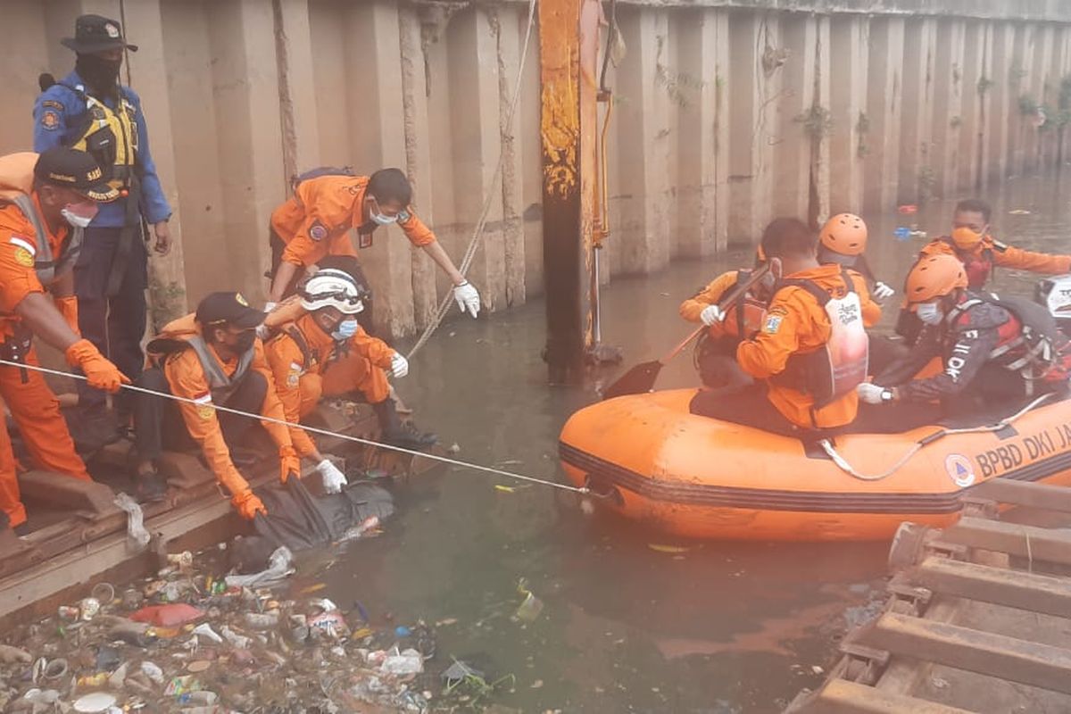 Petugas melakukan evakuasi jenazah Solihin (20), pemuda yang tenggelam di kawasan Banjir Kanal Barat, Tambora, Jakarta Barat, pada Minggu (29/8/2021).