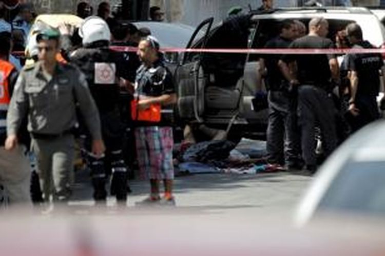 Anggota kepolisian Israel berkerumun di sekitar jasad seorang pria Palestina yang tewas ditembak setelah mobil yang dikemudikannya menabrak dua orang polisi di Jerusalem Timur, Rabu (20/5/2015).