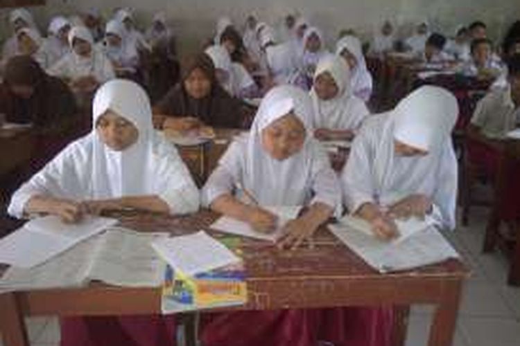 Sejbanyak 64 siswa duduk berdesak-desakan dalam satu kelas di SD Negeri Pondokkaso Tengah, Cidahu, Kabupaten Sukabumi, Jawa Barat, Kamis (10/3/2016). Idealnya setiap rombongan belajar dalam setiap ruang kelas berjumlah sekitar 32 siswa. 
