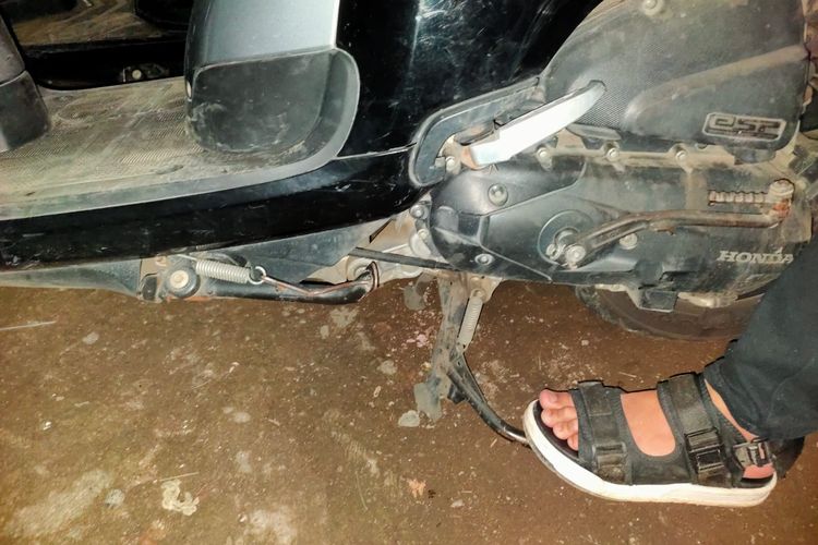 Salah Seorang Pengendara Sepeda Motor Saat Menggunakan Standar Tengah 
