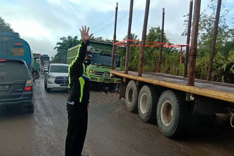 Anggota polisi lalu lintas Polsek Lirik, Bripka Donni Malindo saat berjam-jam mengurai macet di jalan lintas timur akibat antrean panjang kendaraan mengisi solar di SPBU di Kecamatan Lirik, Kabupaten Inhu, Riau, Rabu (16/3/2022).