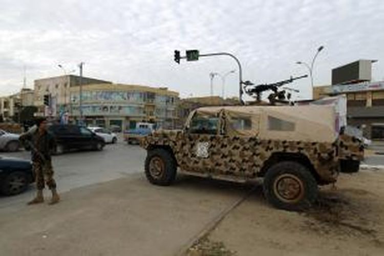 Anggota militer Libya berjaga di dekat kendaraan tempur di kota Benghazi, Libya. Bentrokan antara militer dan kelompok militan Anshar al-Sharia pecah, Senin (25/11/2013), mengakibatkan sedikitnya lima tentara tewas.